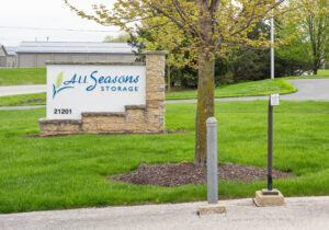 All Seasons Storage entrance sign with stone base and well-maintained grounds in Franksville, WI
