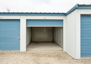 Interior view of an open drive-up storage unit at All Seasons Storage showing concrete floor and lighted space