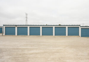 Row of drive-up self storage units with wide gravel access lanes near Muskego, WI